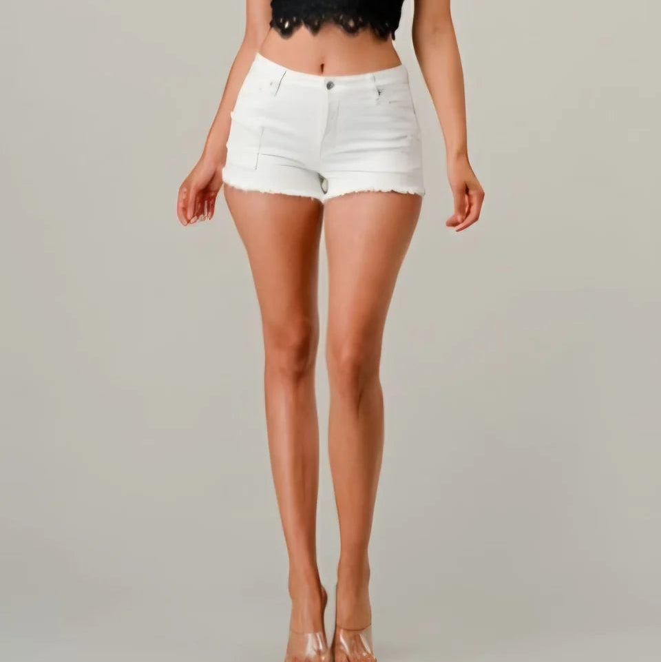 Person wearing white denim shorts on a plain background