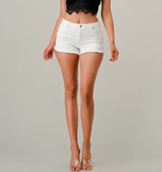 Person wearing white denim shorts on a plain background